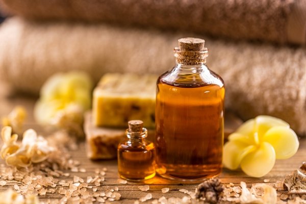 Bottles of essential castor oil on wooden board